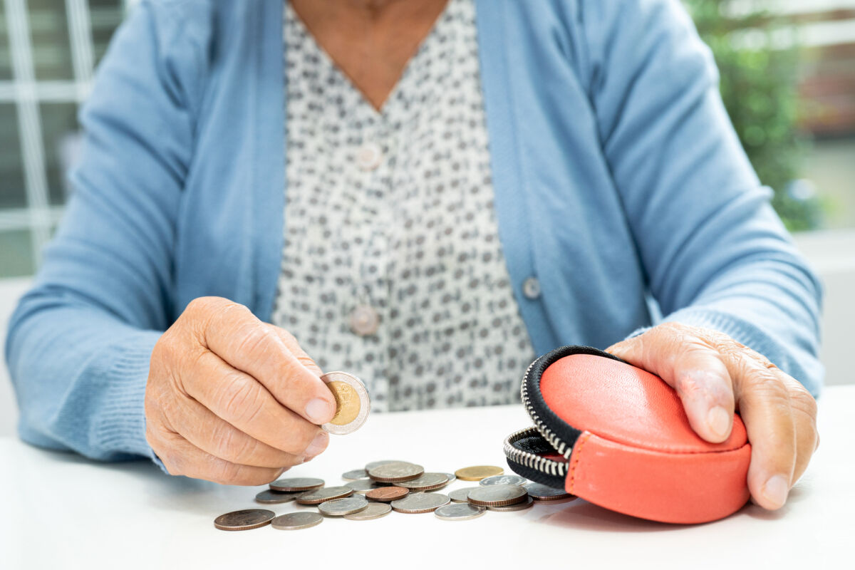 Asian senior or elderly old lady woman holding counting coin money in purse. Poverty, saving problem  in retirement.