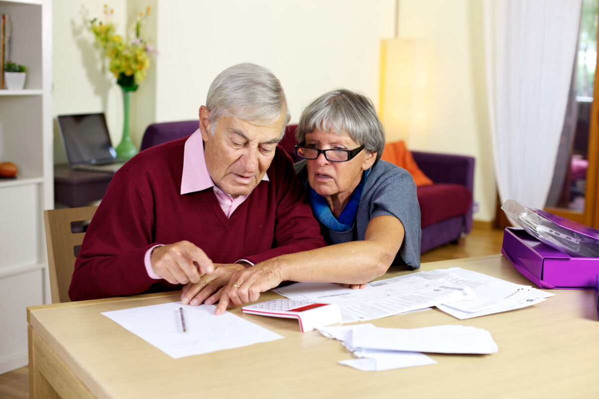 Senior couple at home calculating bills
