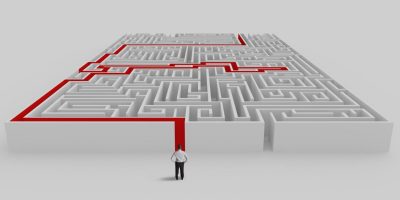 Businessman in front of a maze with solution