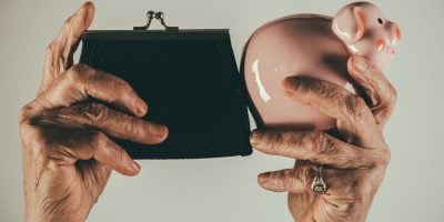 Pension, savings for old age. A purse and a piggy bank. Deposit, collect money. Poor old age. Poor old lady keeps her wallet and collects money for travel. Female elderly hands