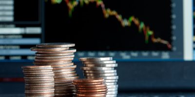 Stacks of coins  and a down trend chart as the background