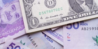 dollar bill over Colombian pesos, close up