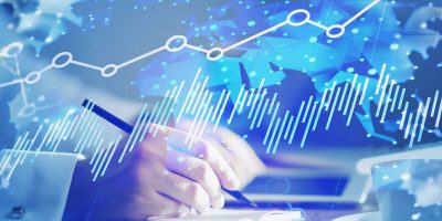 Hand of businessman working in blurry office with double exposure of world map and digital diagram. Concept of world trade and stock market analysis. Toned image