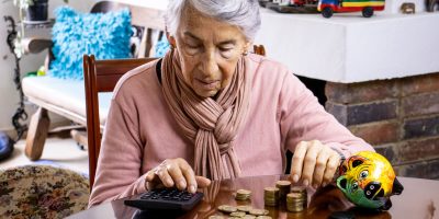 Senior woman sitting at her home saving money