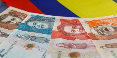 Colombian money, pesos, against the background of the colors of the national flag