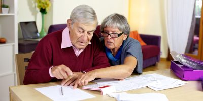 Senior couple at home calculating bills