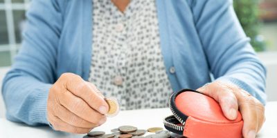Asian senior or elderly old lady woman holding counting coin money in purse. Poverty, saving problem  in retirement.