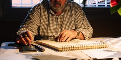 Portrait of an elderly man with a concentrated expression while drawing. Old people activities concept.