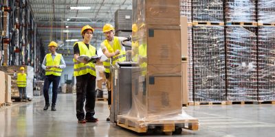 Employees Consult While Working In The Warehouse V2L6TMN